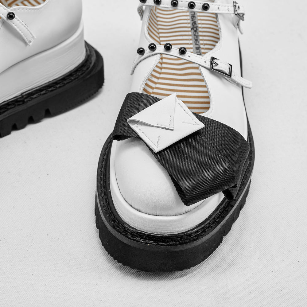 White shoes with black sole and strap on a white background