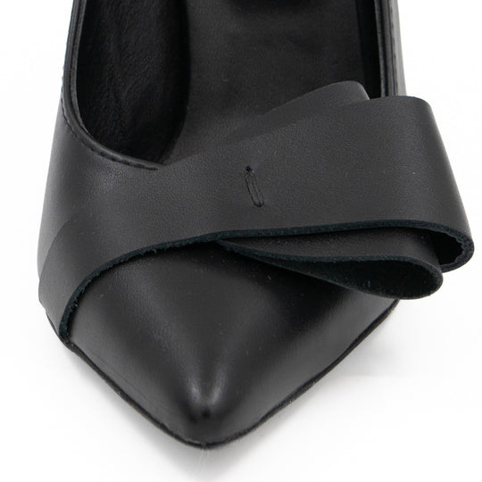 Close-up of the folded black leather bow and pointed toe on After Party pumps.