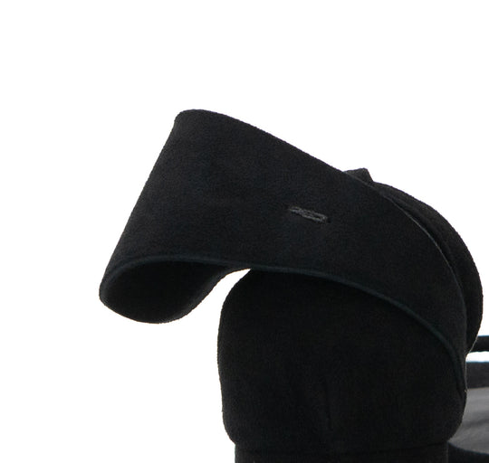 Close-up of the sculptural black suede bow at the back of a Back to Bow sandal.