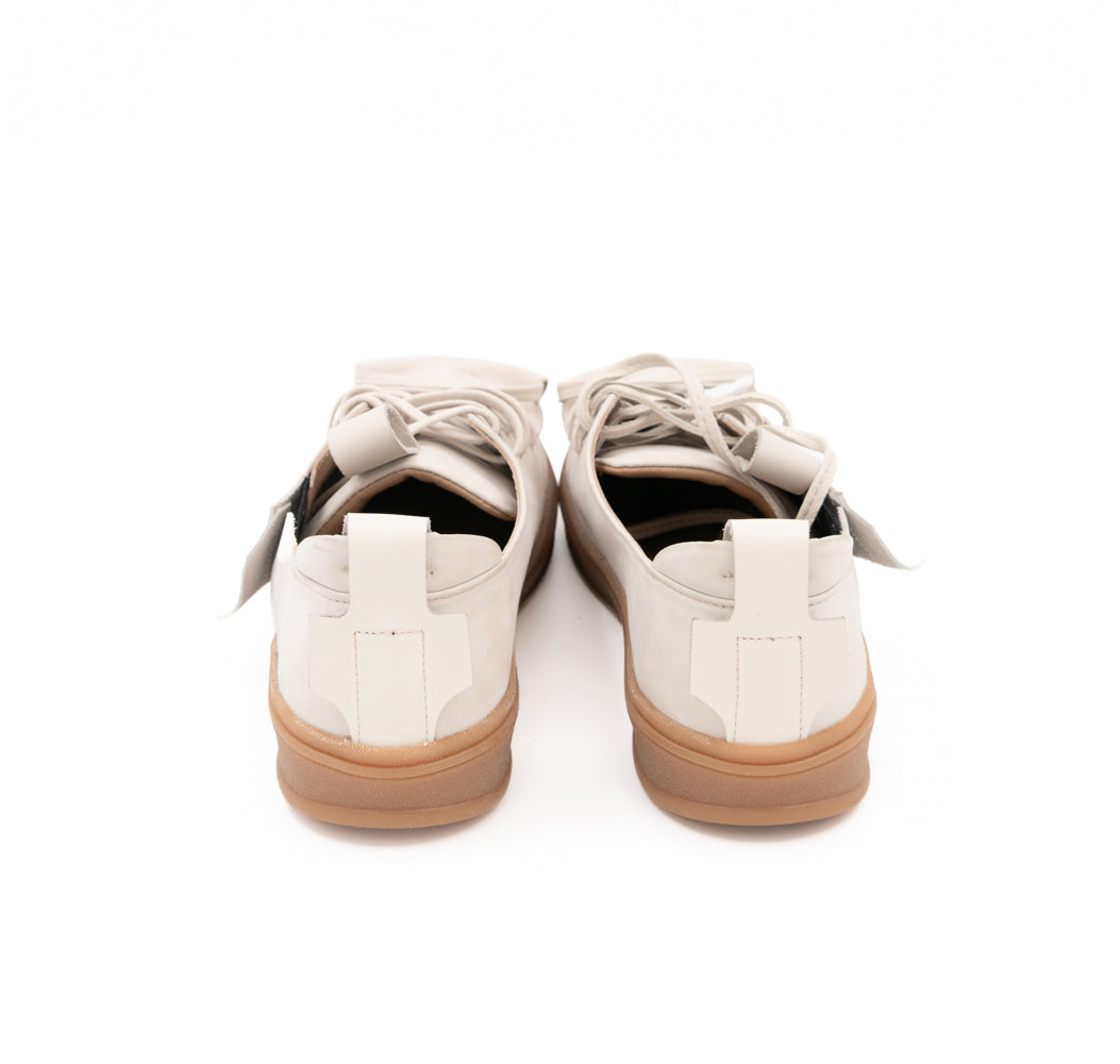 Rear view of Crossroads light beige nubuck sneakers, showing leather pull tabs, open details and beige soles.