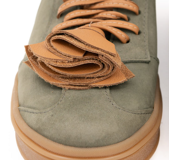 Close-up of the layered tan leather flower and laces on Make This Flower Great Again  khaki nubuck sneakers.