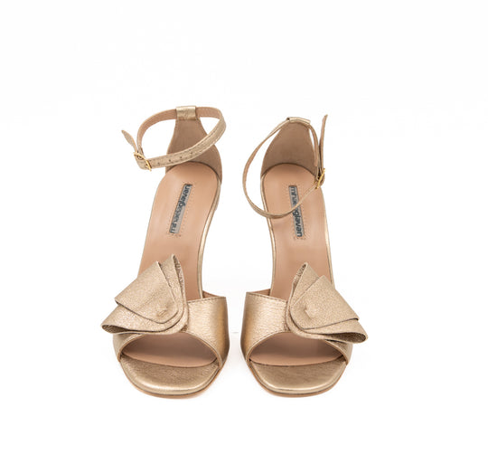 Moondust Gold leather sandals by Mihaela Glavan, front view showing the reinterpreted bows and open toes.