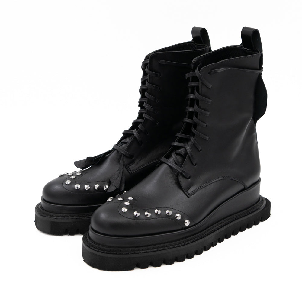 Punk Dreamer black leather lace-up booties by Mihaela Glavan, three-quarter view showing the studs, floral details and geometric soles.