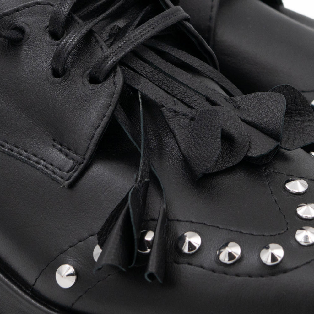 Punk Dreamer black leather lace-up shoes by Mihaela Glavan, close-up of the raised leather flower, waxed laces and metal studs.