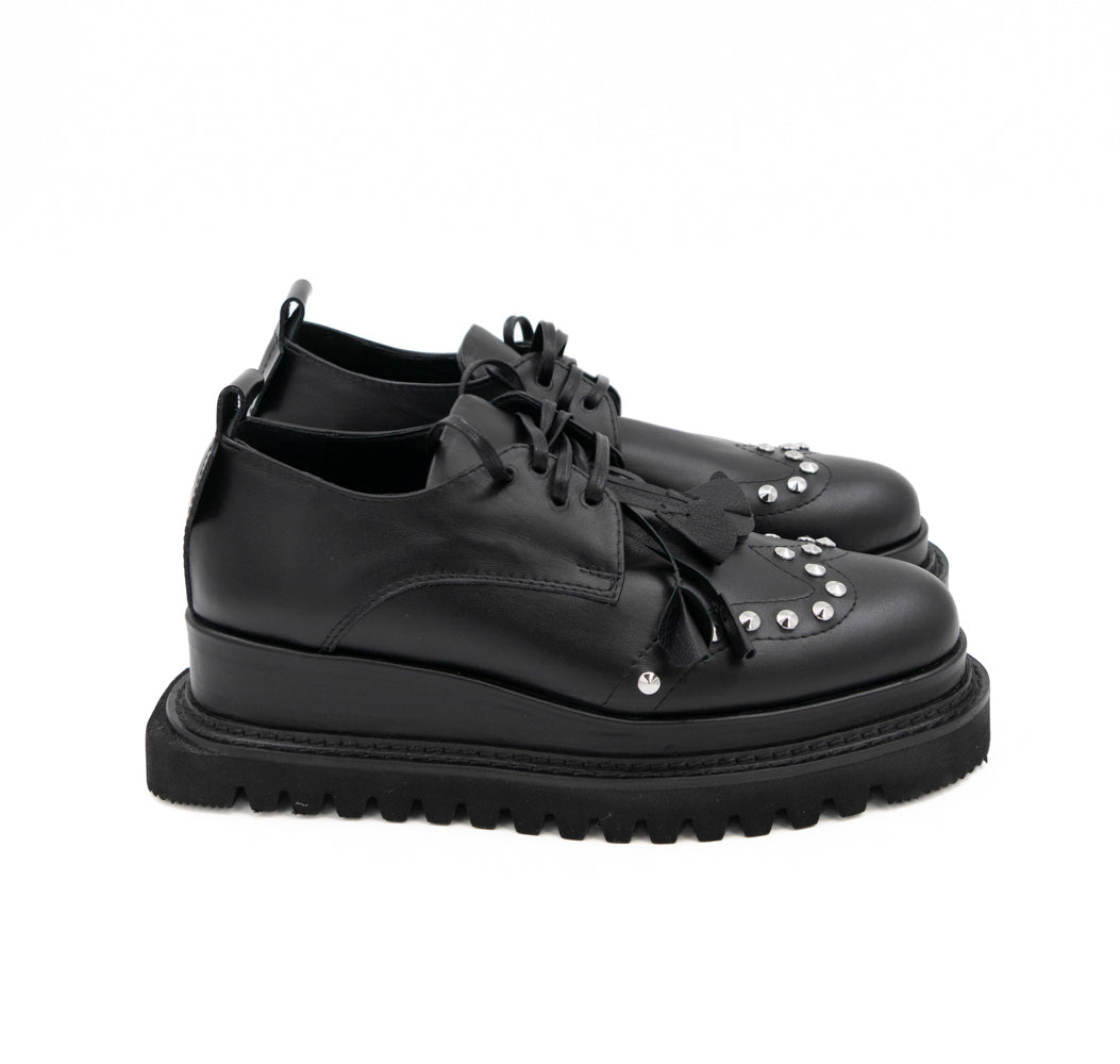 Punk Dreamer black leather lace-up shoes by Mihaela Glavan, rear three-quarter view showing the leather panels and black midsole.