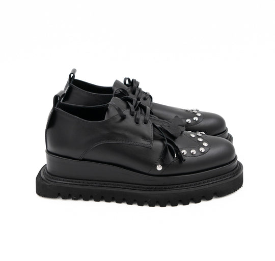 Punk Dreamer black leather lace-up shoes by Mihaela Glavan, rear three-quarter view showing the leather panels and black midsole.