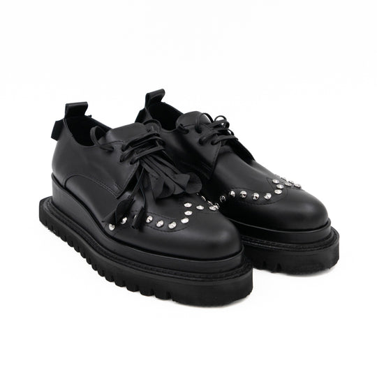 Punk Dreamer black leather lace-up shoes by Mihaela Glavan, three-quarter view showing the floral details, studs and chunky black soles.