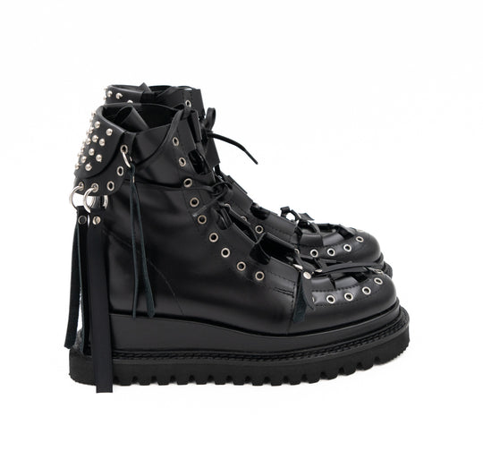 Punk Lover black leather lace-up booties by Mihaela Glavan, side view showing the studded back panel and hanging leather strips.