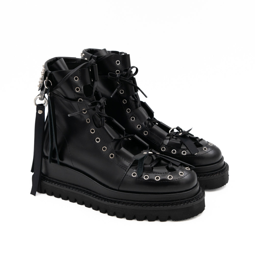 Punk Lover black leather lace-up booties by Mihaela Glavan, three-quarter view showing the eyelets, studs and hanging back details.
