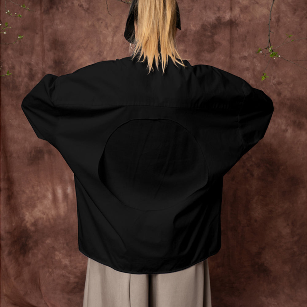Close-up of the circular back detail on the Solar Disk black oversized cotton shirt.