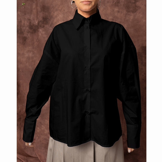Front view of the Solar Disk black shirt, showing the collar, button fastening and long sleeves with pleated cuffs.