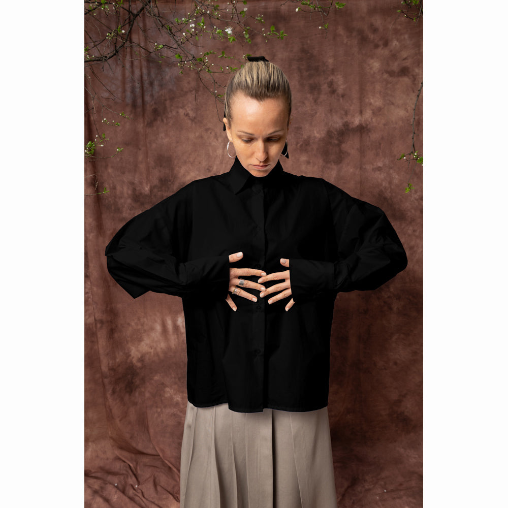 Solar Disk black oversized cotton shirt worn from the front, showing the dropped shoulders and relaxed fit.