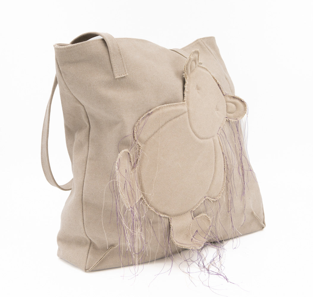 Teddy vegan beige textile totebag showing its side depth and stitched bear applique from an angle.