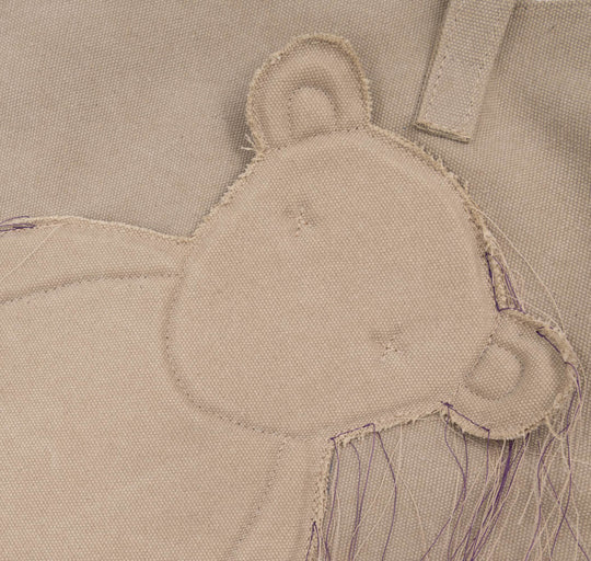 Close-up of the bear head applique, visible stitching and loose threads on the Teddy beige textile totebag.