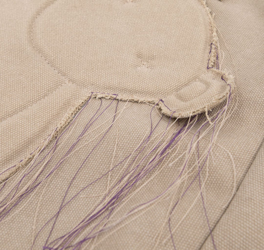Close-up of the stitched bear applique and trailing threads on the Teddy beige textile totebag.