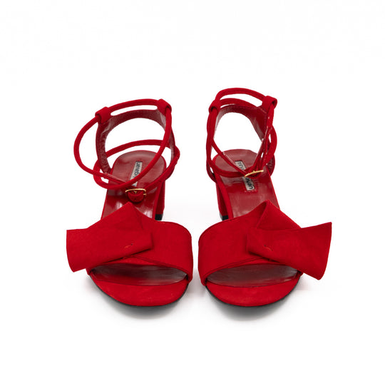 Front view of Trick Me red suede sandals, showing the folded bows, open toes and ankle straps.