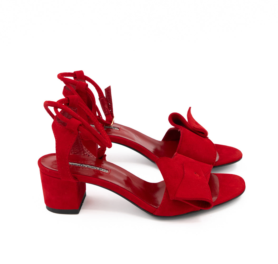 Side view of Trick Me red suede sandals, with 5.5 cm block heels, ankle straps and black soles.