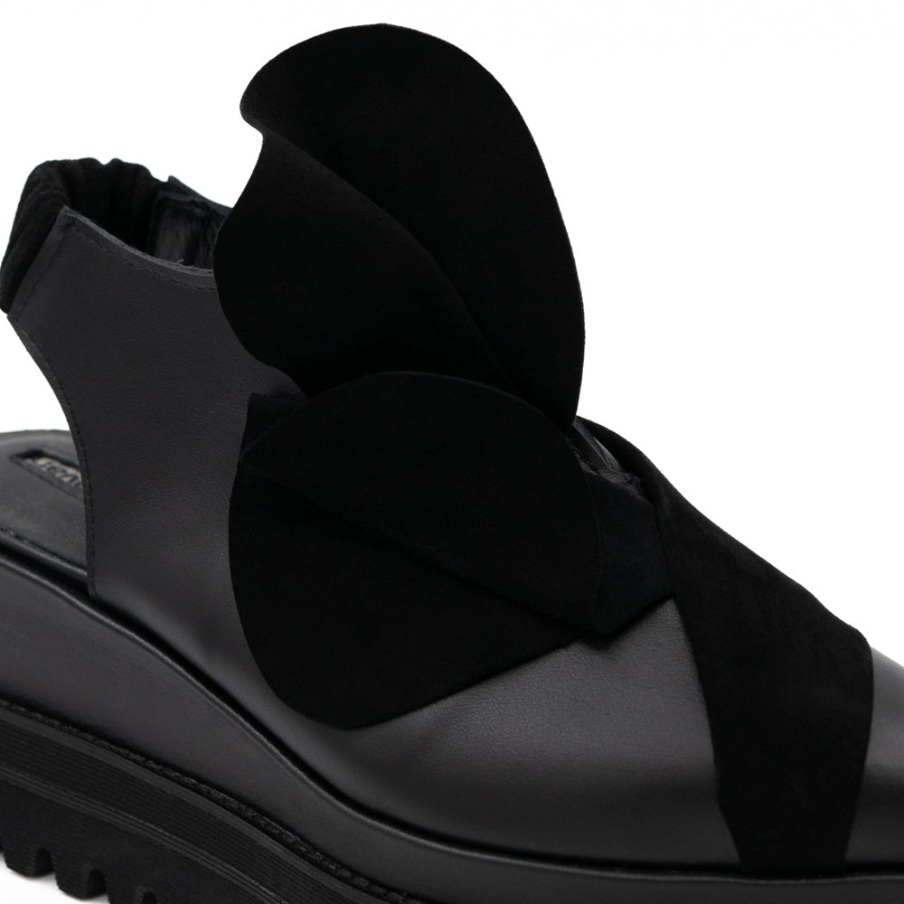 Close-up of the 3D black suede flower on Tulips black leather open-back shoes.