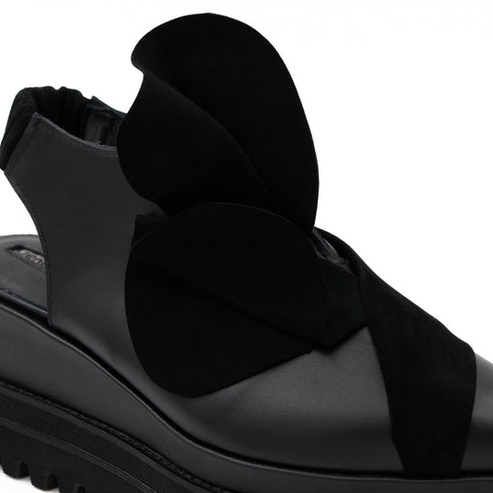 Close-up of the 3D black suede flower on Tulips black leather open-back shoes.