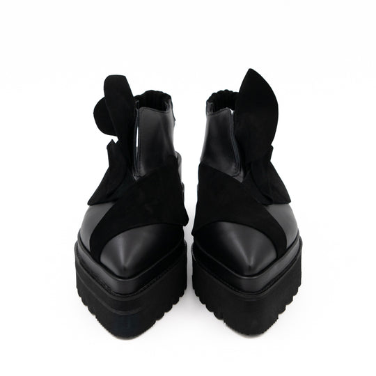 Front view of Tulips black leather open-back shoes, with pointed toes and 3D black suede petals.