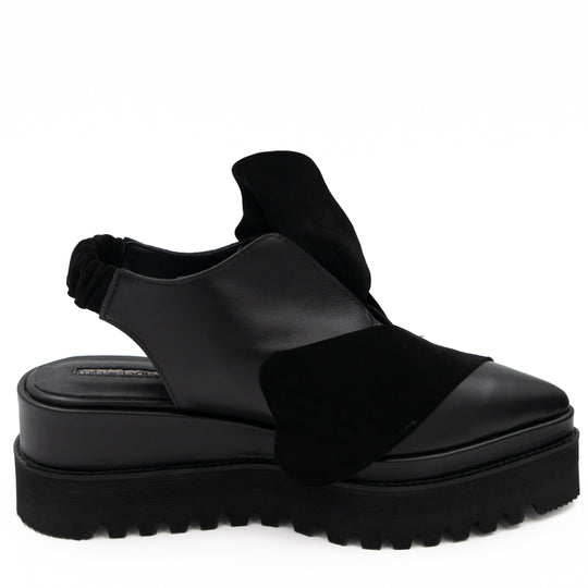 Side view of Tulips black leather open-back shoes, showing the cut-outs, elastic back strap and raised sole.